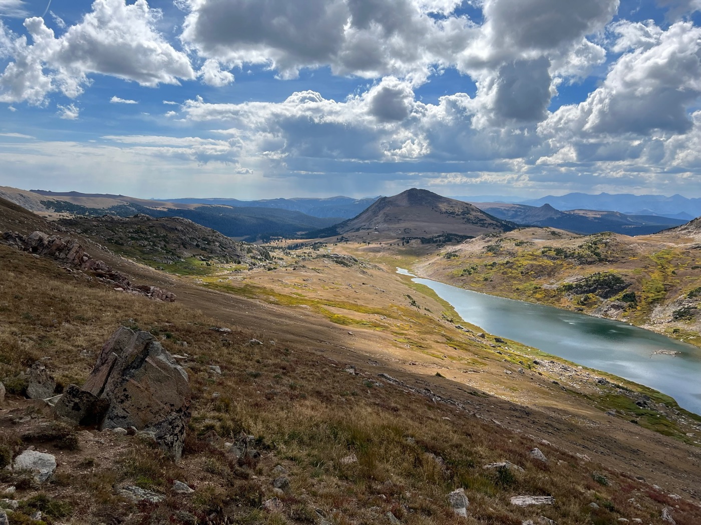 Alpine basin with a lake under storm clouds