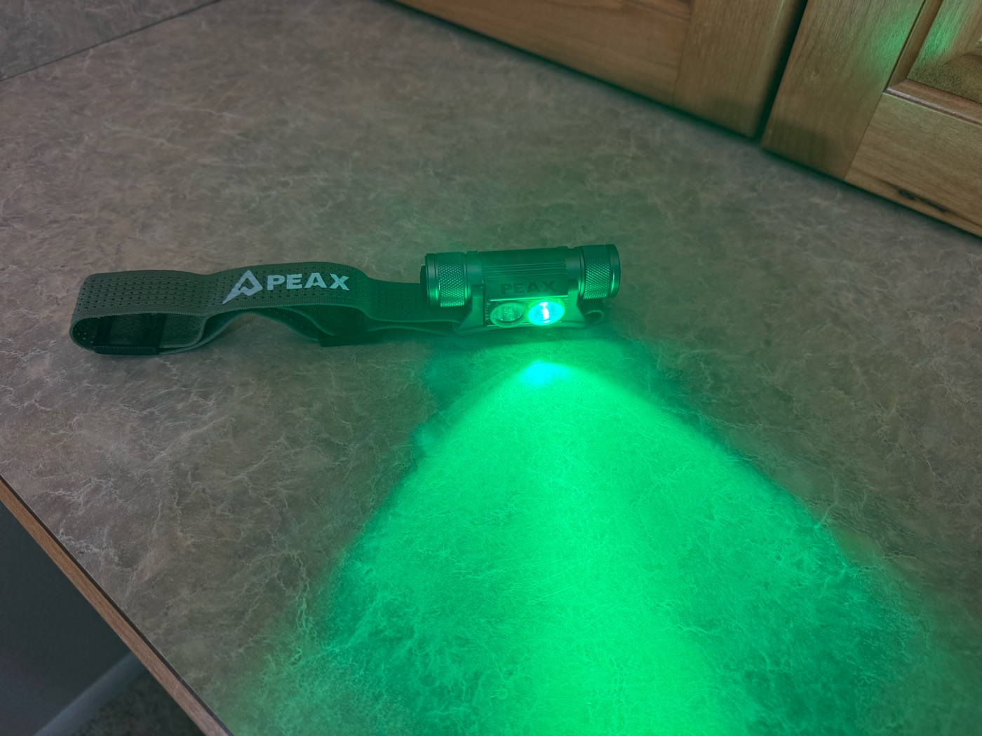 PEAX headlamp with the green mode on, casting a bright green beam