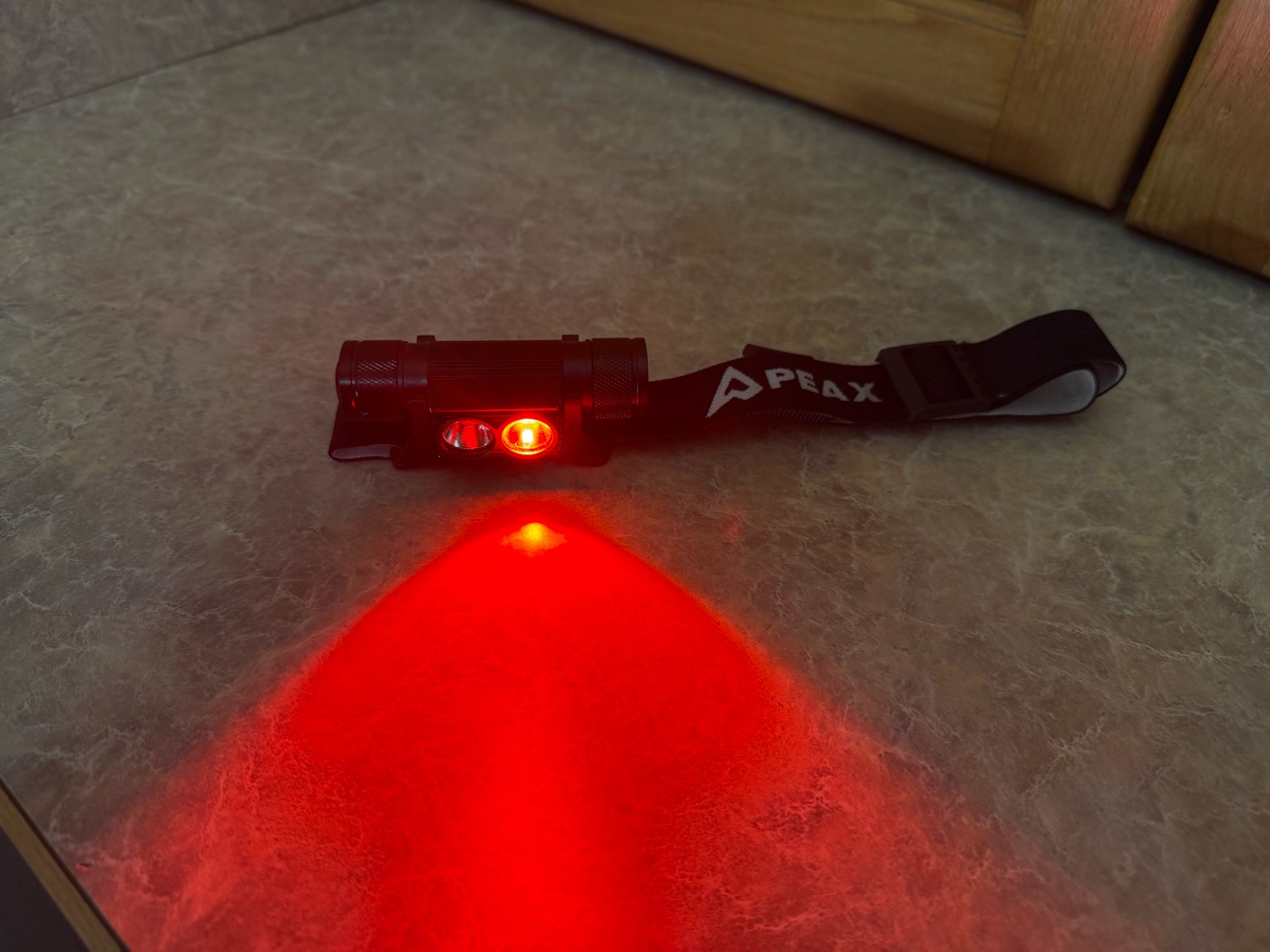 PEAX headlamp with the red mode on, casting a red beam