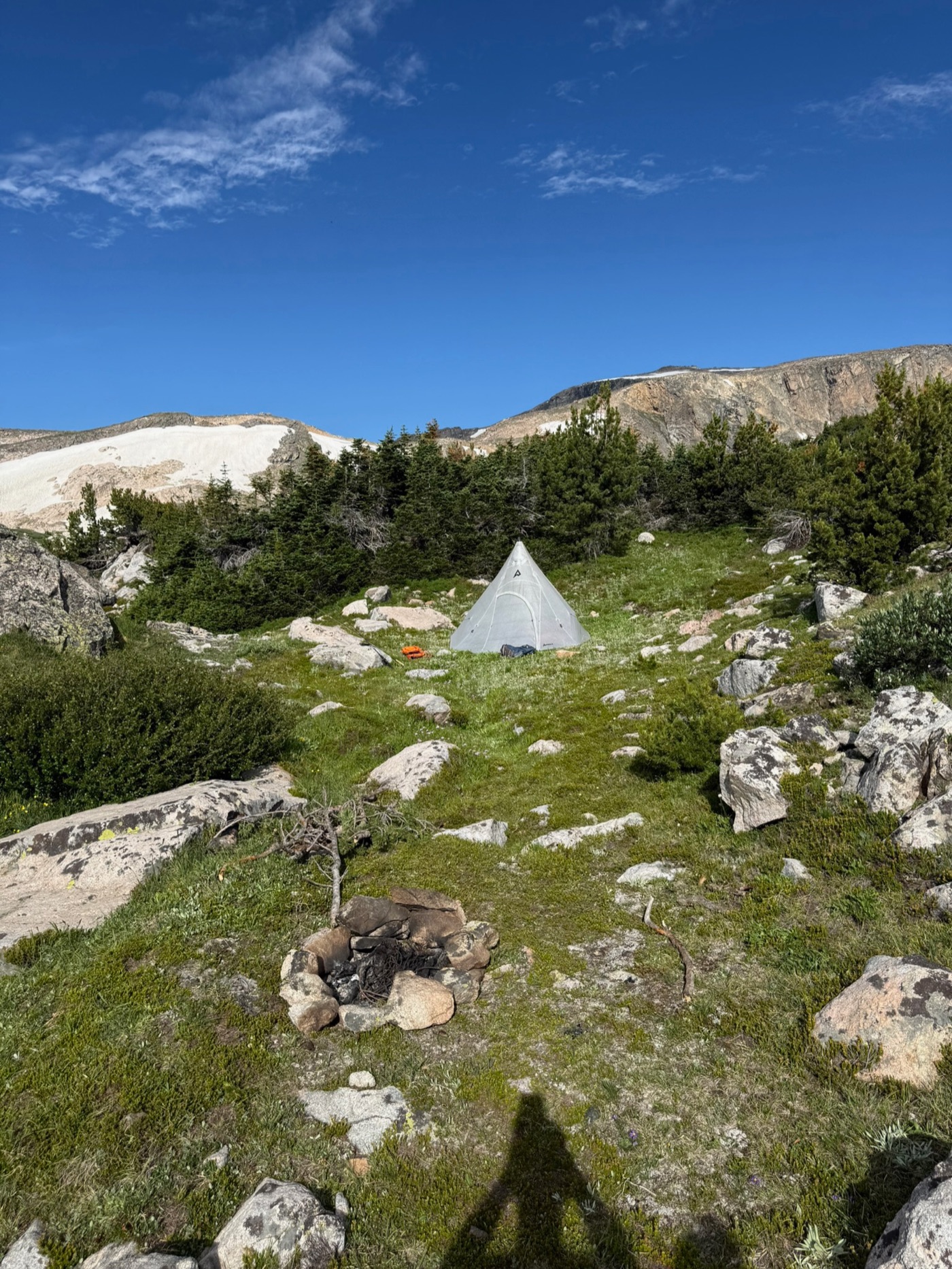 PEAX tipi pitched in a protected alpine meadow with an established fire ring
